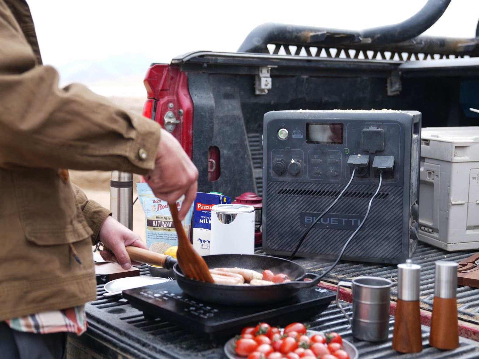 Man using BLUETTI AC240 portable power station while camping to cook